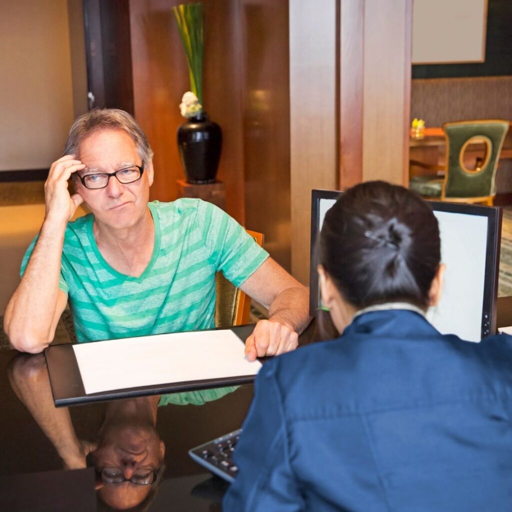 The Essential Guide To Hotel Check In and Check Out (2025) Hawaii Calling Man reviewing hotel bill