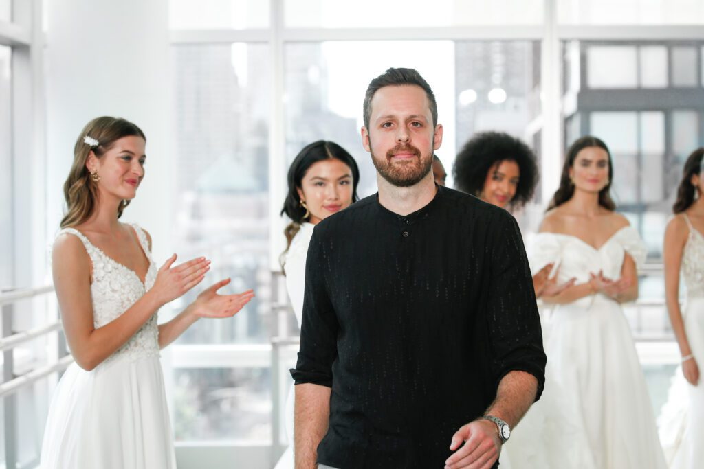Ultimate Guide to Marriott Bonvoy Moments for 2023 Hawaii Calling Justin Warshaw of Justin Alexander Design walking among brides in dresses for one of the Marriott Bonvoy Moments