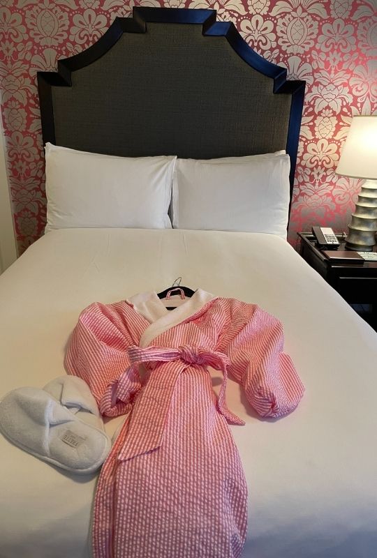 Review & Video: The Royal Hawaiian, Waikiki, A Luxury Collection Hotel Hawaii Calling a pink robe and slippers on a bed