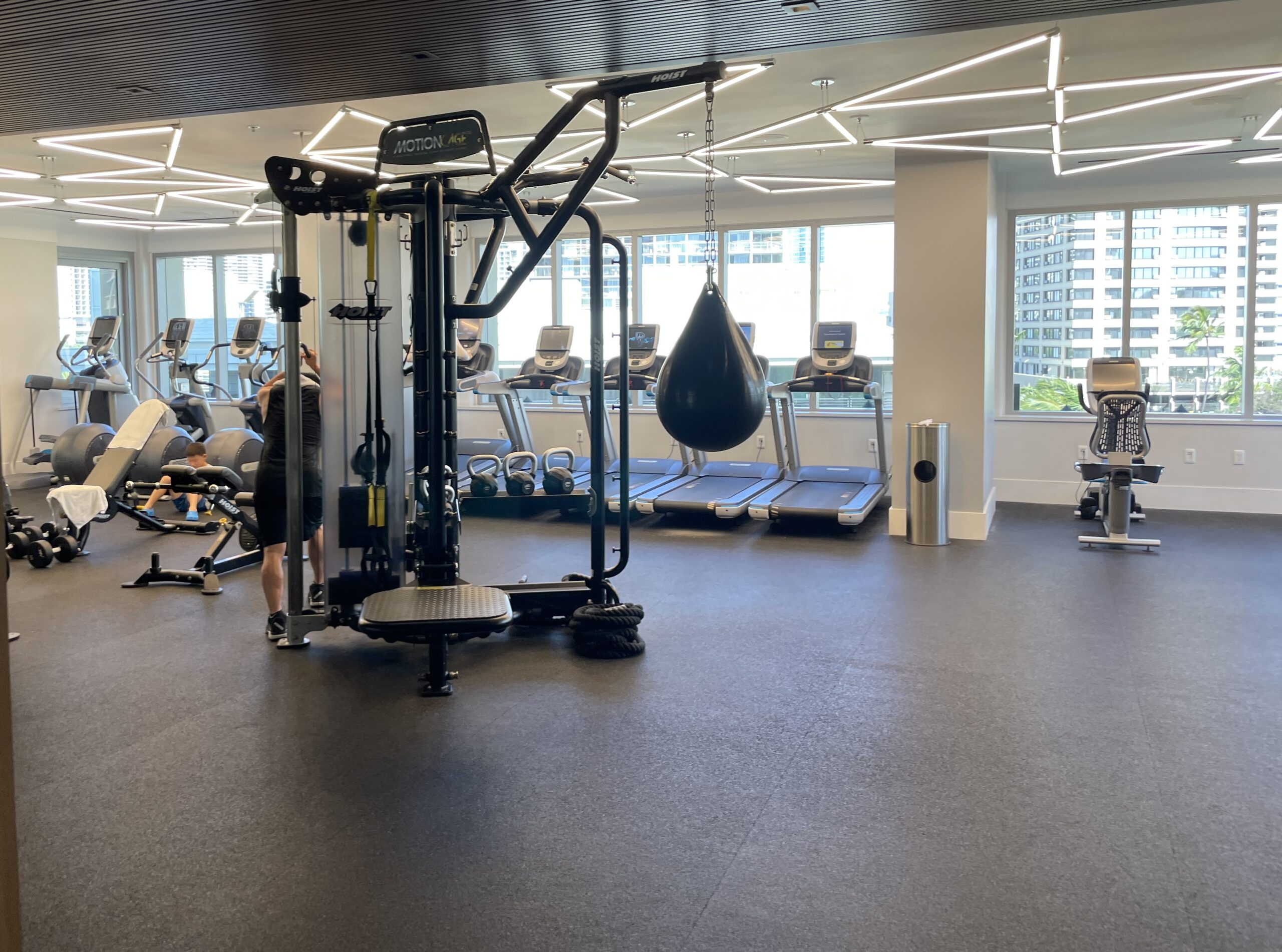 Review & Video: The Ritz-Carlton Waikiki Beach, Luxurious Residences & Hotel Hawaii Calling a gym with exercise equipment and people in the background