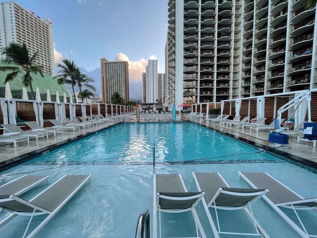 Review & Video: Waikiki Beach Marriott Resort & Spa Hawaii Calling a pool with chairs and a building in the background
