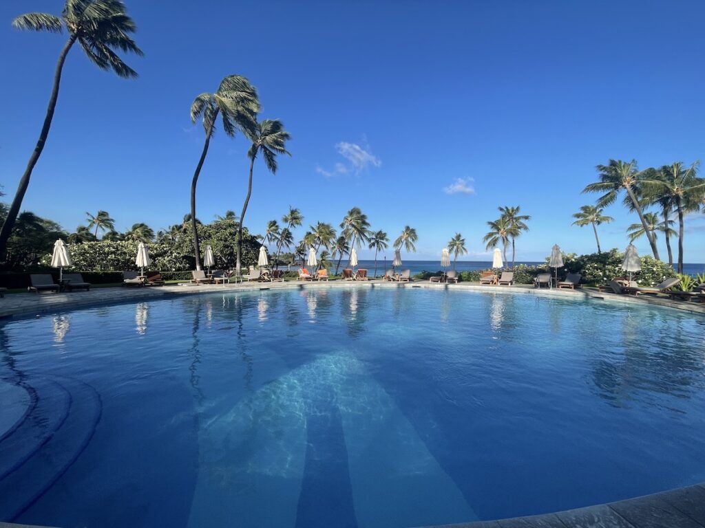 Review & Video: Mauna Kea Beach Hotel, Autograph Collection Hawaii Calling a pool with palm trees and umbrellas