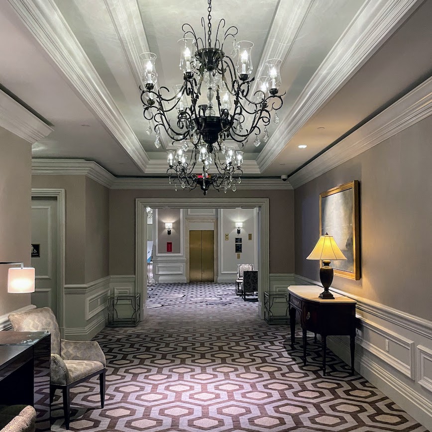 Review & Video: The Ritz-Carlton Washington DC, Refined Luxury Hawaii Calling a hallway with a chandelier and a table
