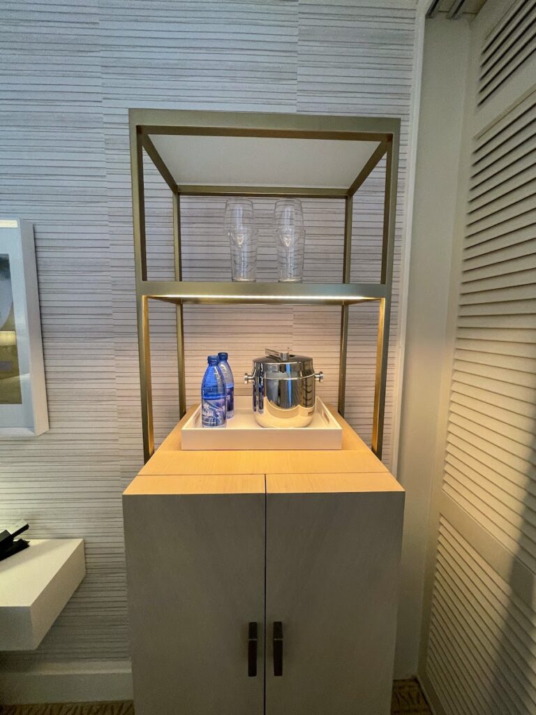 a shelf with a pot and water bottles on it