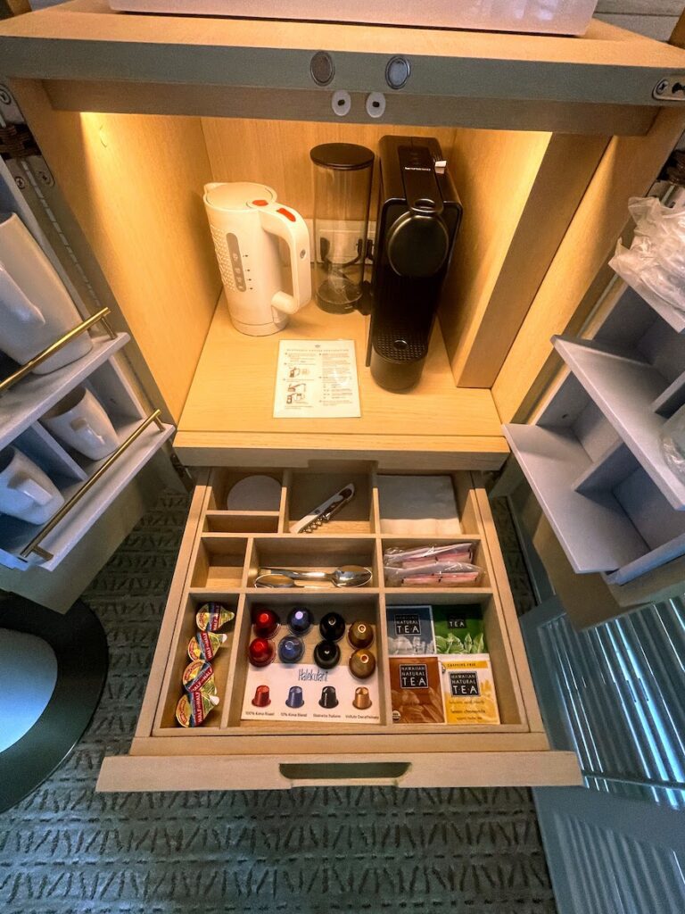a drawer with a coffee maker and other items inside