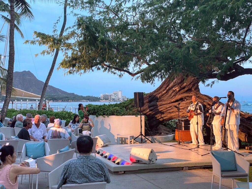 a group of people on a stage under a tree