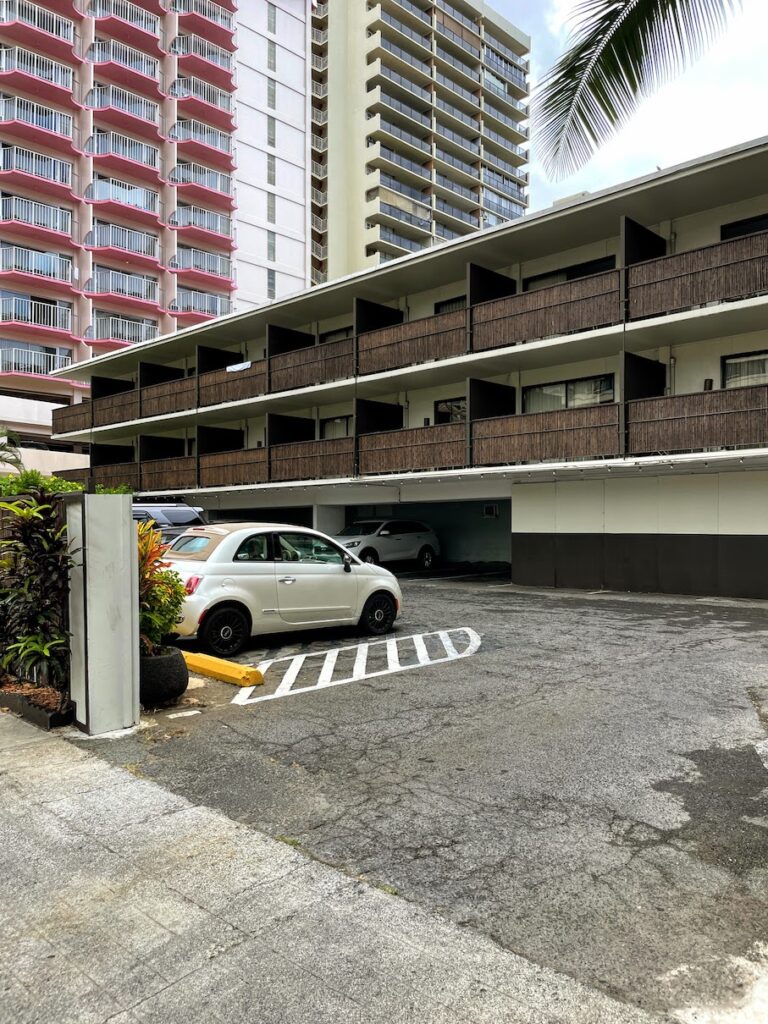 Review & Video: White Sands Hotel, Boutique & Smart Hawaii Calling a parking lot with cars parked in front of a building