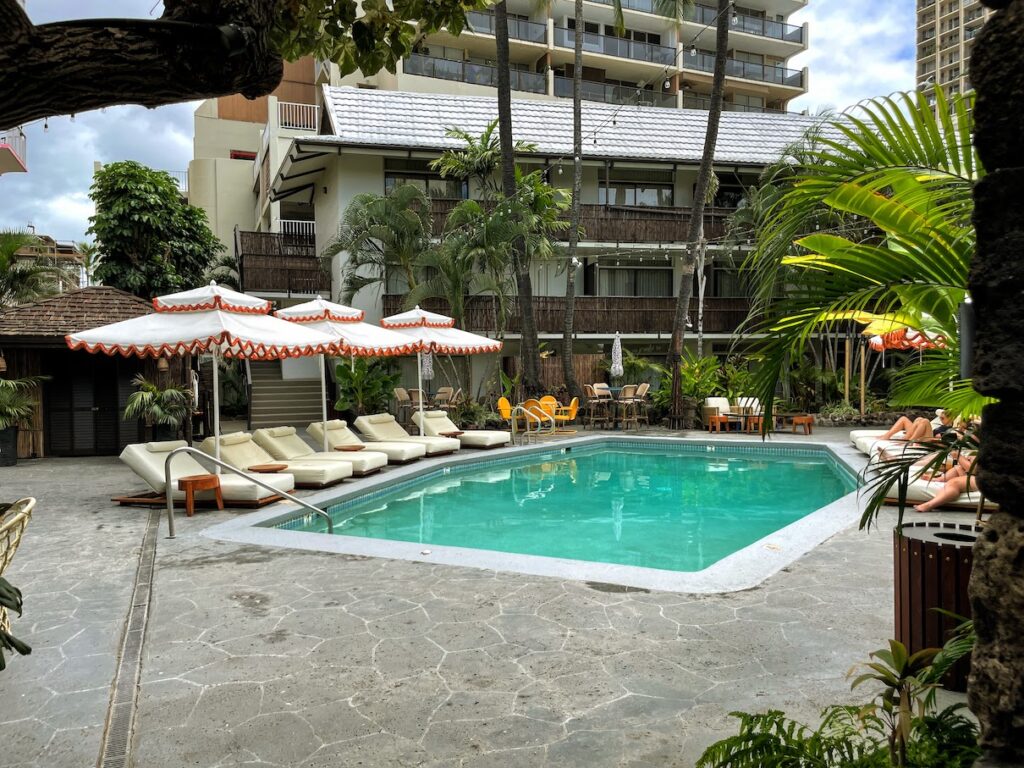 Review & Video: White Sands Hotel, Boutique & Smart Hawaii Calling a pool with lounge chairs and umbrellas in front of a building