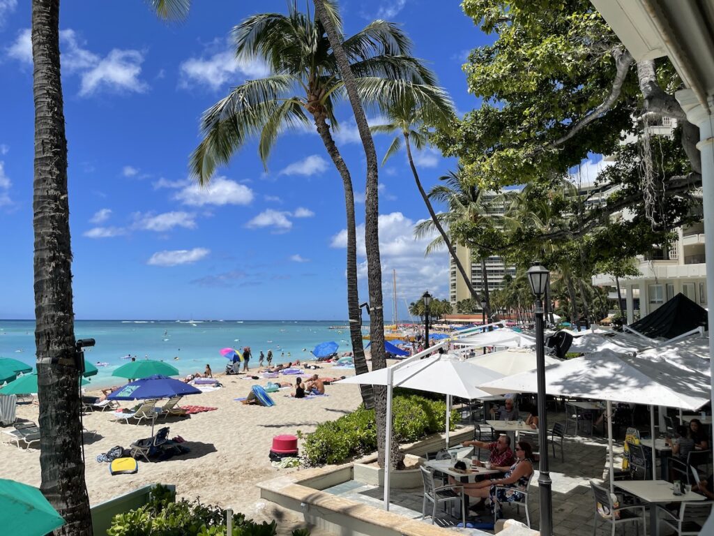Review & Video: Moana Surfrider, Waikiki Beach Beauty Hawaii Calling a beach with palm trees and people on it
