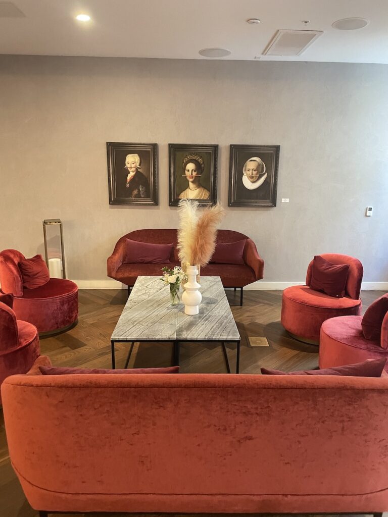 Review & Video: The Guild Hotel, San Diego, a Tribute Portfolio Hotel Hawaii Calling a room with red chairs and a table with a vase of flowers