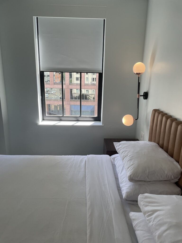 Review & Video: The Guild Hotel, San Diego, a Tribute Portfolio Hotel Hawaii Calling a bed with pillows and a lamp