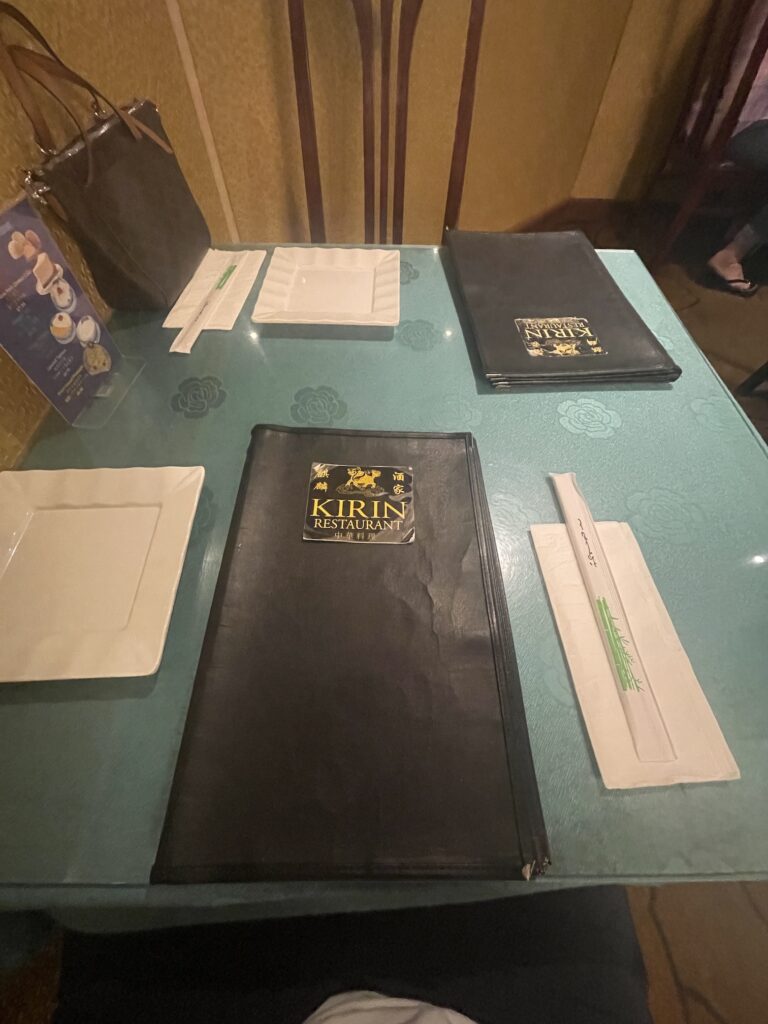 Kirin Waikiki | Mysterious Underground Dinner Review Hawaii Calling a table with a menu and plates