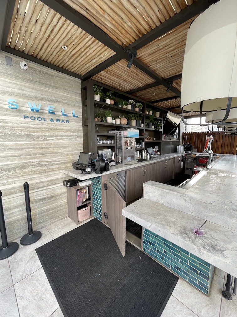 Review & Video: 'Alohilani Resort Waikiki Beach, A Unique Oasis Hawaii Calling a bar with a counter and a sign