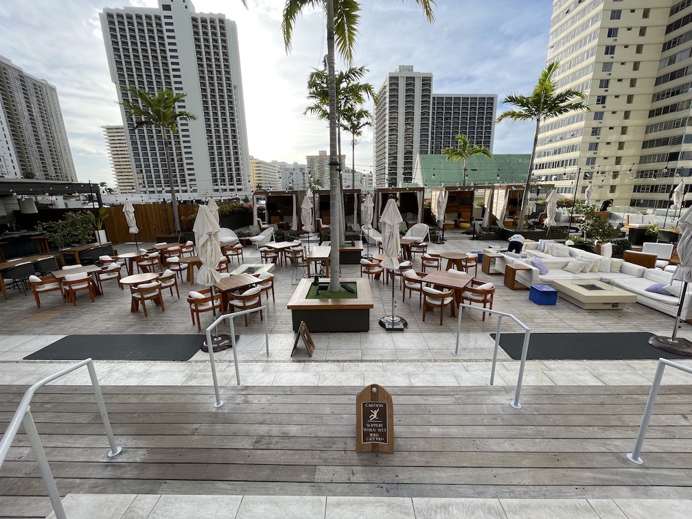 Review & Video: 'Alohilani Resort Waikiki Beach, A Unique Oasis Hawaii Calling a patio with tables and chairs and palm trees
