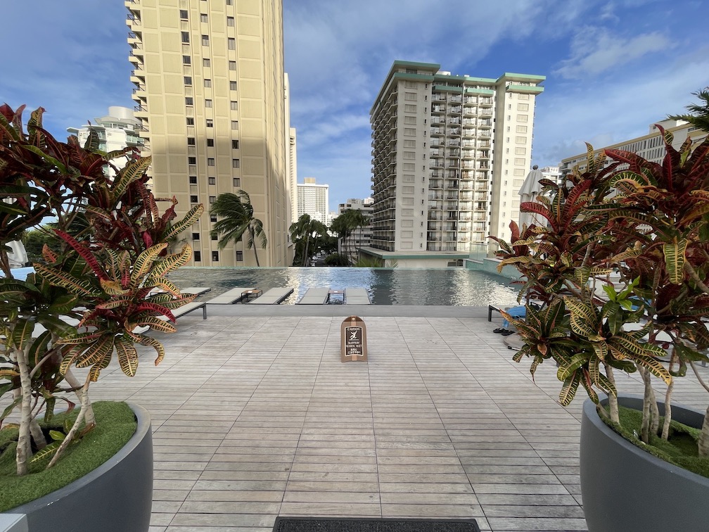 Review & Video: 'Alohilani Resort Waikiki Beach, A Unique Oasis Hawaii Calling a pool with trees and buildings in the background