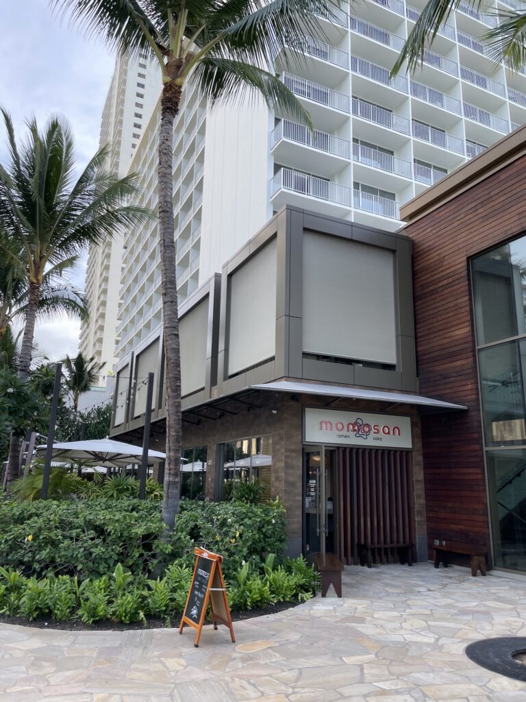 Review & Video: 'Alohilani Resort Waikiki Beach, A Unique Oasis Hawaii Calling a building with palm trees and a sign