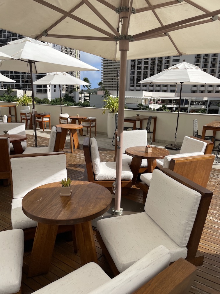 Review & Video: 'Alohilani Resort Waikiki Beach, A Unique Oasis Hawaii Calling a patio with tables and chairs and umbrellas