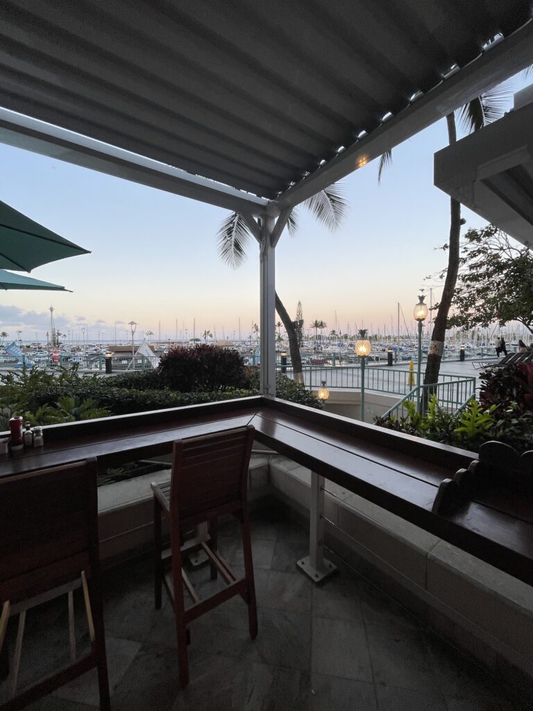 Cinnamon's Ilikai Waikiki | Legendary Breakfast Review Hawaii Calling a table and chairs outside with a view of a marina and boats in the background