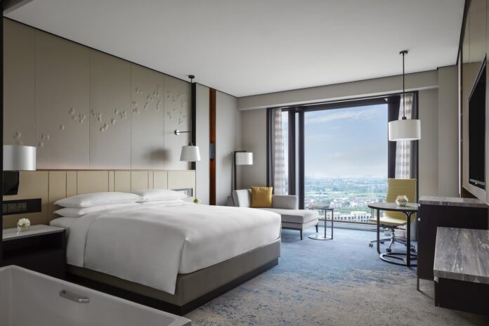 a room with a bed and chairs and a window