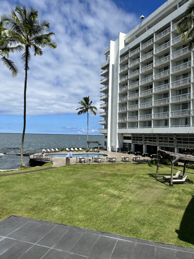 5 Best Budget Friendly Hotels in Hawaii for (2025) Hawaii Calling a large white building with a pool and palm trees