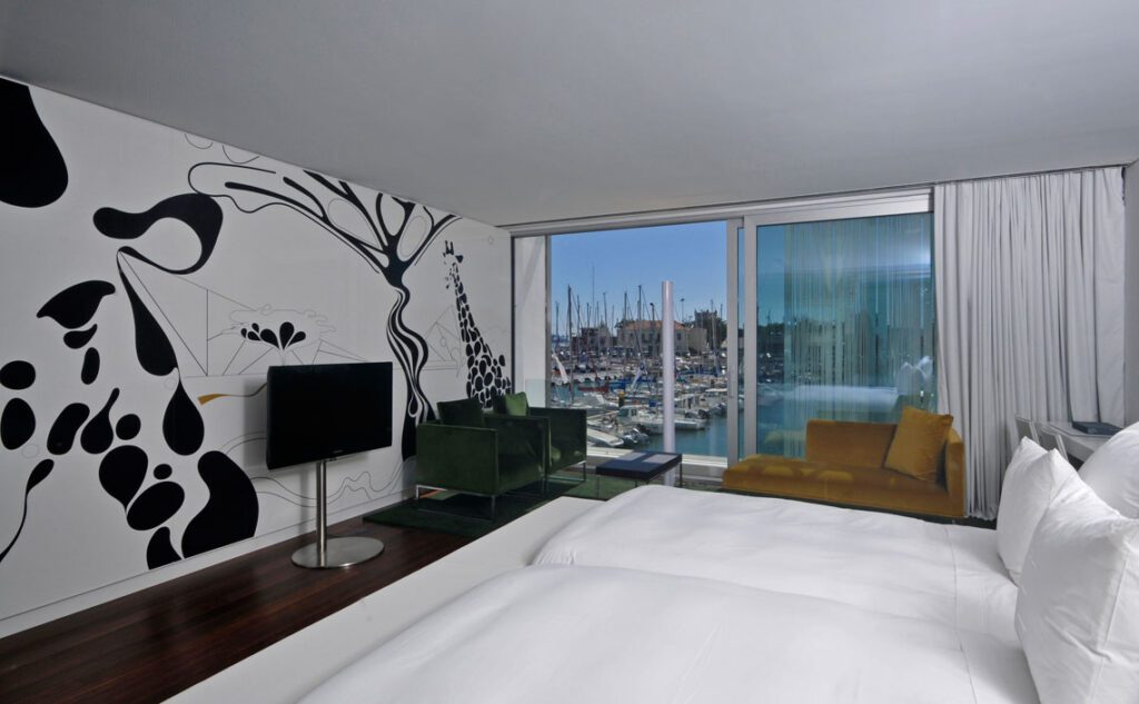The 5 Best Luxury Hotels in Lisbon 2022 Hawaii Calling a room with a tv and a wall with boats in the background