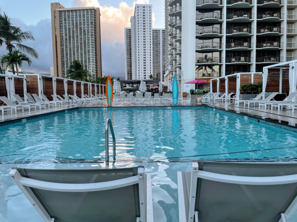 Review & Video: Waikiki Beach Marriott Resort & Spa Hawaii Calling a pool with chairs and a building in the background