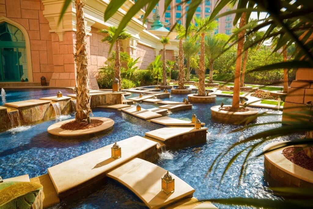 Virtuoso Travel: A Guide To Exclusive Perks & Benefits Hawaii Calling a pool with a waterfall and trees