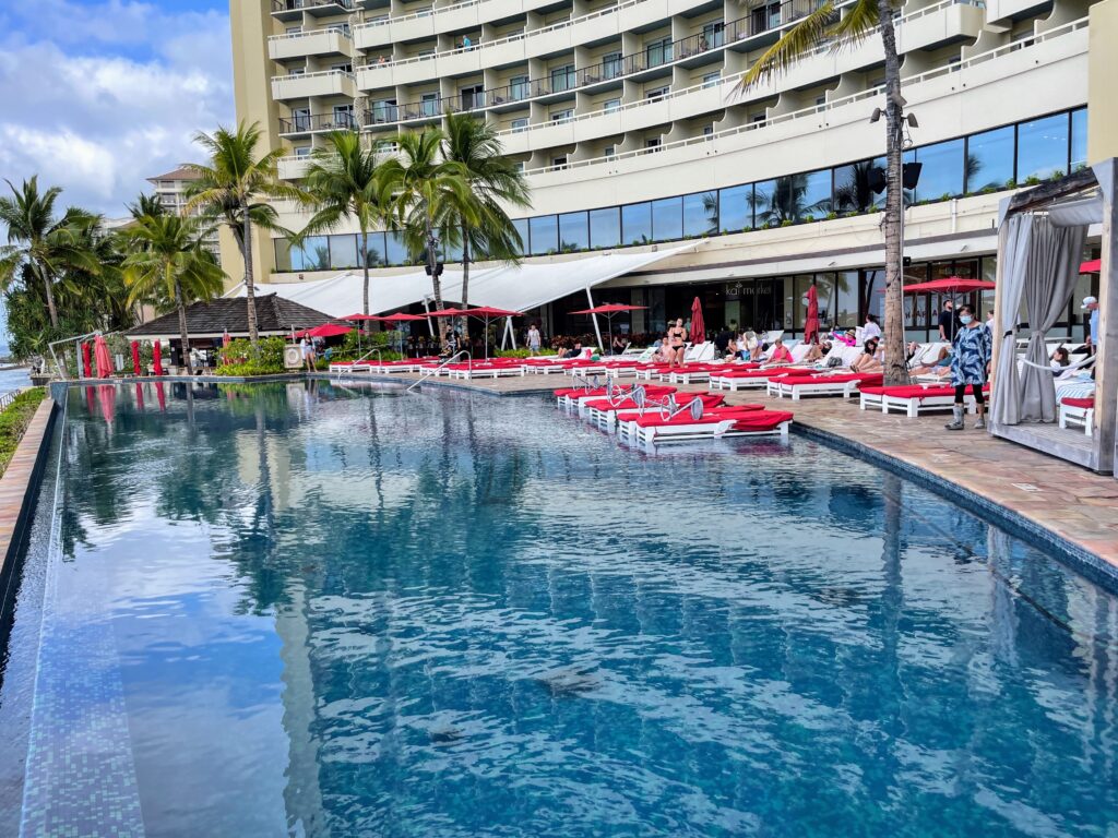 Review & Video: Sheraton Waikiki, Best Family Hotel on Oahu Hawaii Calling a pool with lounge chairs and umbrellas in front of a building