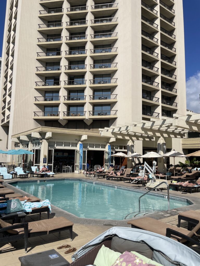 Review: Hyatt Regency Waikiki, Amazing With An Achilles Heel Hawaii Calling a pool with chairs and umbrellas in front of a building