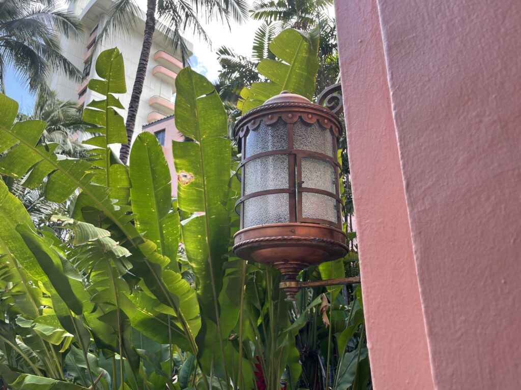 5 Key Features To Know When Deciding Between The Sheraton Waikiki Vs. Royal Hawaiian Hotel Hawaii Calling a lamp in front of a pink wall
