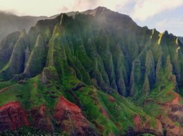 a green mountain with sand and water