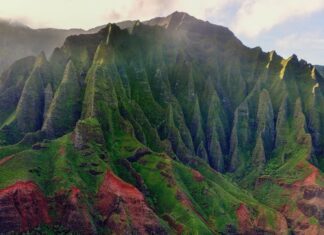 10 Essential Things to Pack For Your Trip To Hawai’i a green mountain with sand and water