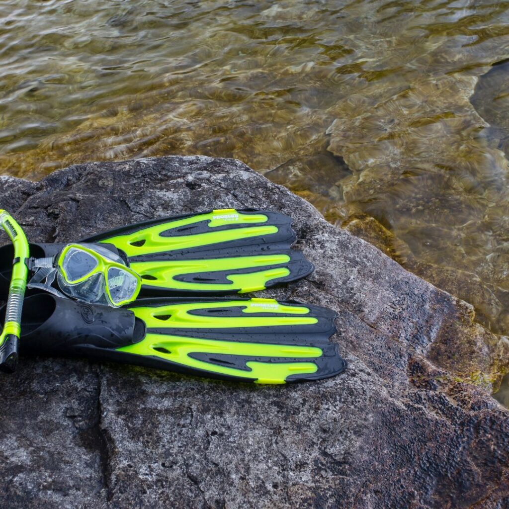 10 Essential Things to Pack For Your Trip To Hawai'i Hawaii Calling a snorkeling gear on a rock by water