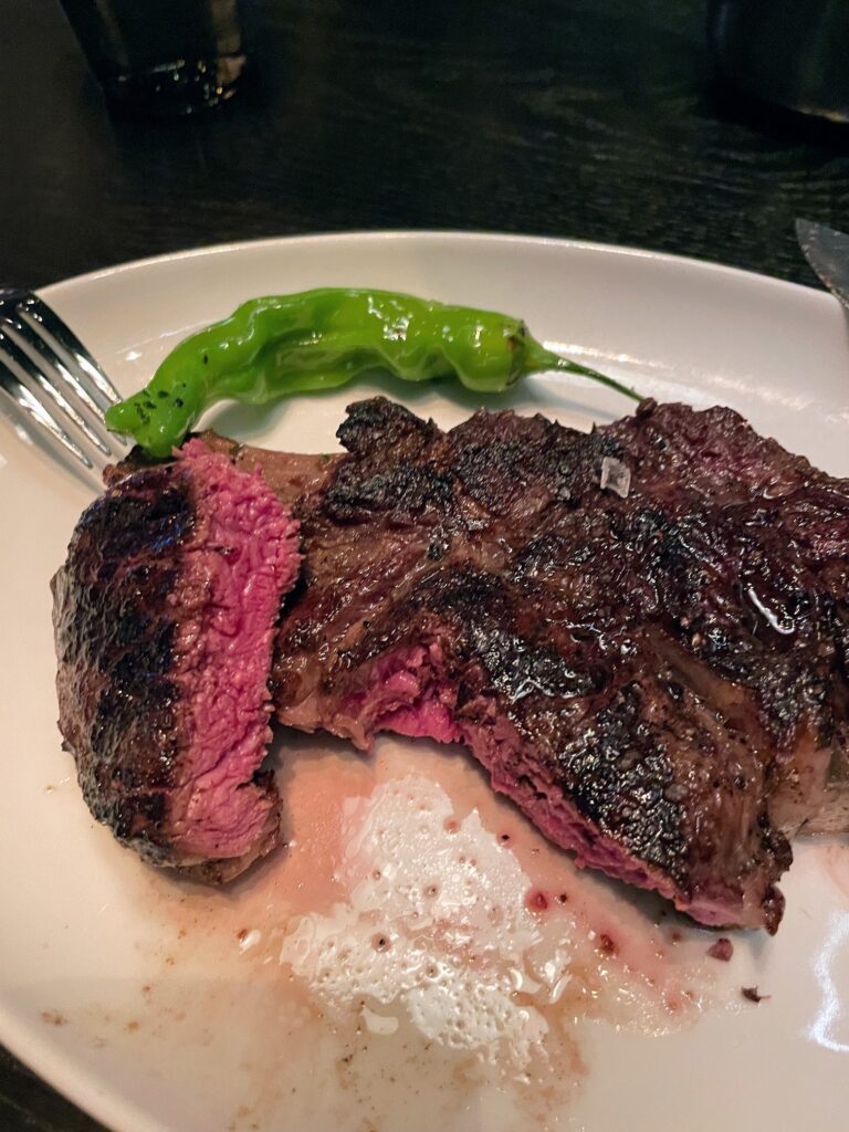 Classy Cool STRIPSTEAK Las Vegas | Review & Video Hawaii Calling a piece of steak with a green pepper on a white plate