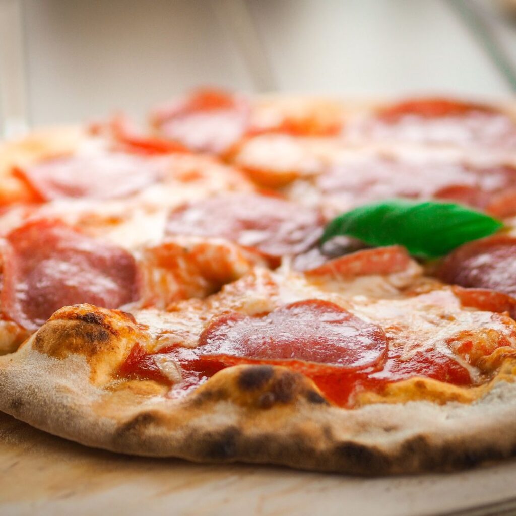 7 Best Pizza Spots In Lahaina, Maui Hawaii Calling a pizza with pepperoni and cheese on a wood surface