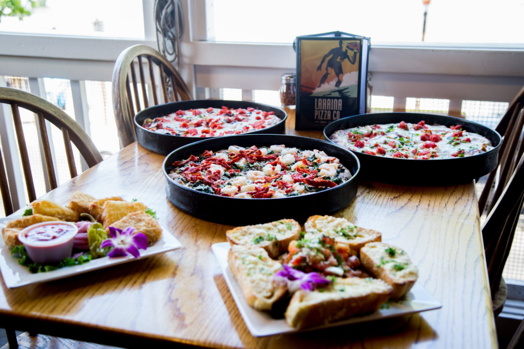 7 Best Pizza Spots In Lahaina, Maui Hawaii Calling a table with food on it