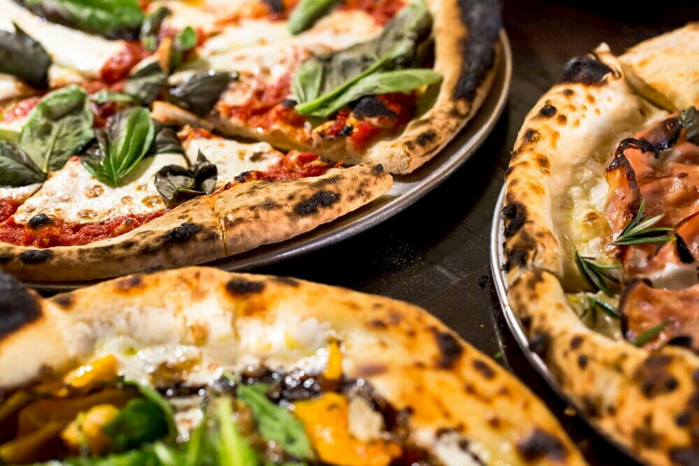 7 Best Pizza Spots In Lahaina, Maui Hawaii Calling a group of pizzas on a table