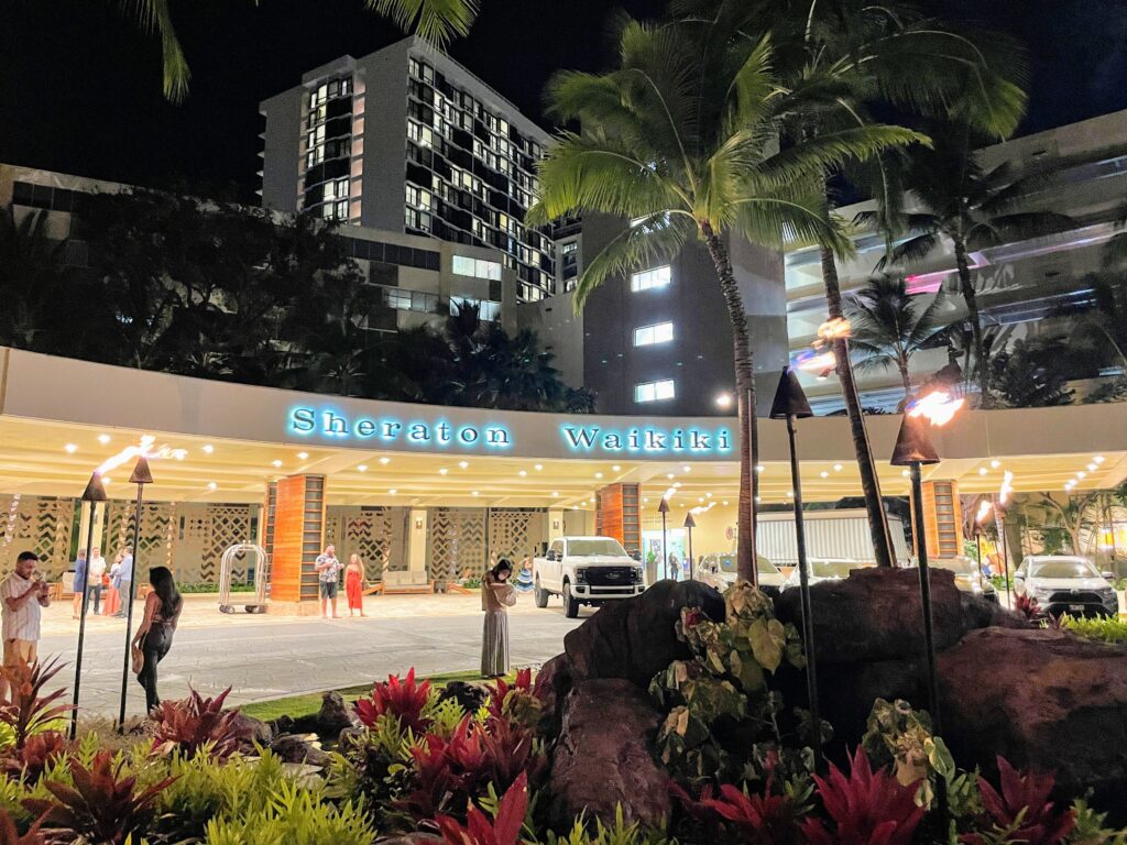 Legendary Sheraton Waikiki Vs. Moana Surfrider | 6 Things to Consider Hawaii Calling a building with palm trees and a street with a sign