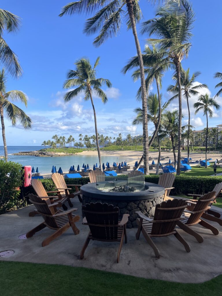 Review & Video | Marriott Ko Olina Beach Club An Amazing Location Hawaii Calling a group of chairs around a fire pit on a patio with palm trees and a beach