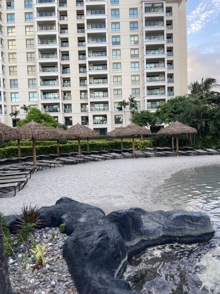 Review & Video | Marriott Ko Olina Beach Club An Amazing Location Hawaii Calling a beach with umbrellas and chairs in front of a building