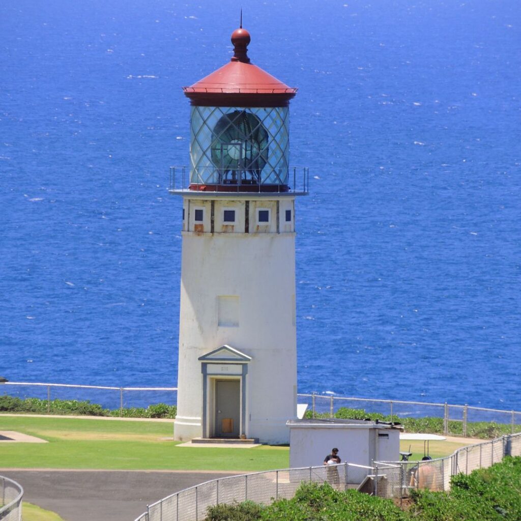 The 30 Best Things To Do On Kauai | A Bucket List Guide (2025) Hawaii Calling a lighthouse with a red roof and a blue body of water