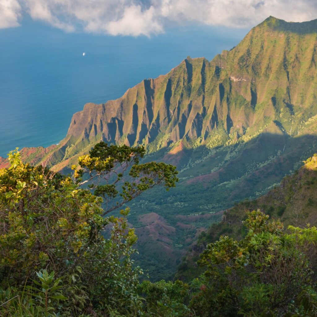 The 30 Best Things To Do On Kauai | A Bucket List Guide (2025) Hawaii Calling a mountain range with trees and water in the background