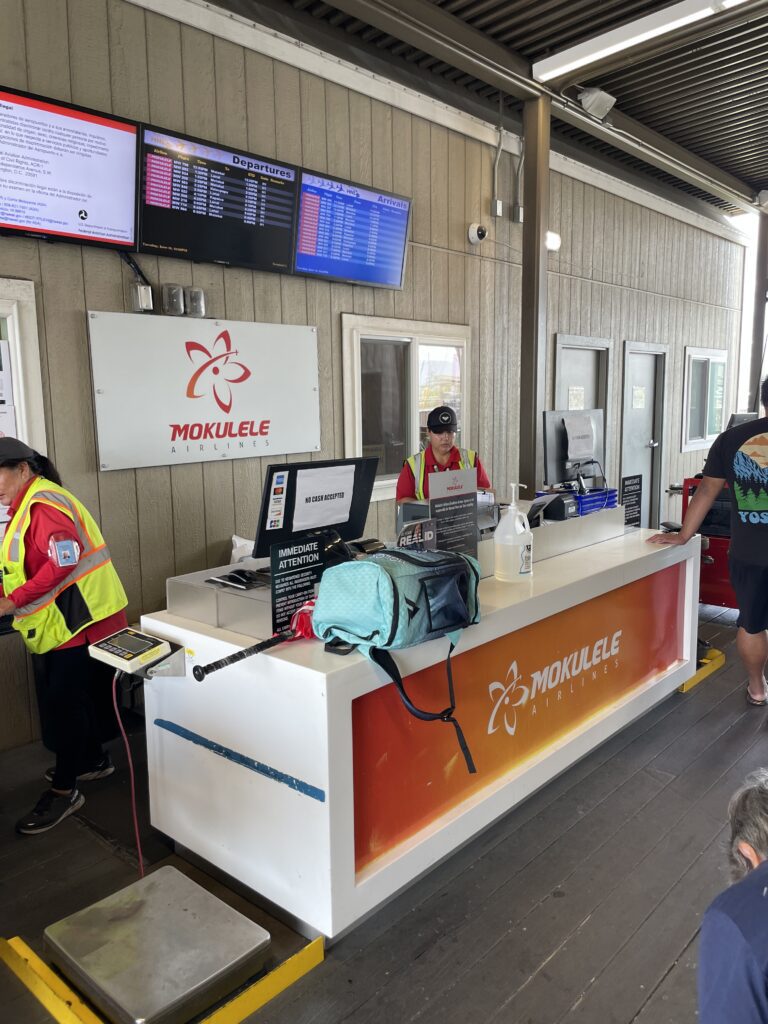 Mokulele Flight Review Honolulu To Kapalua | Exciting Small Plane Adventure Hawaii Calling a man standing at a counter in a building