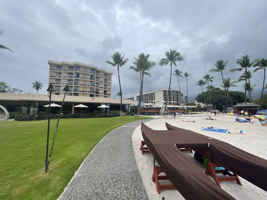 7 Best Family Hotels On The Big Island Hawaii Calling a beach with palm trees and a building