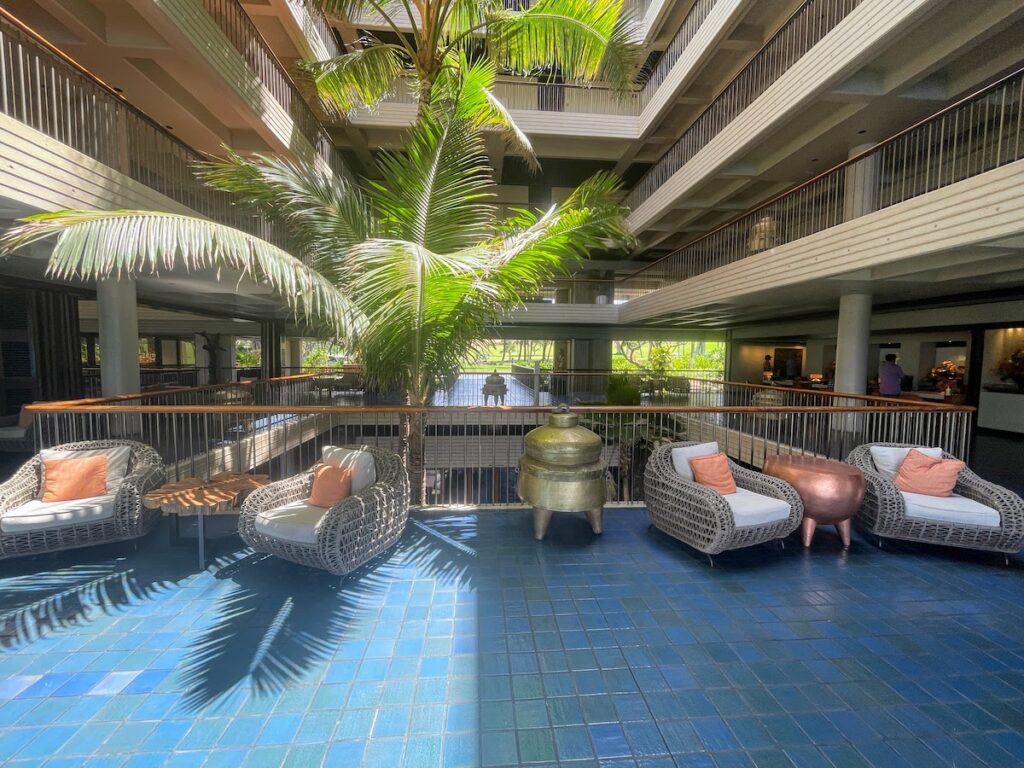 7 Best Family Hotels On The Big Island Hawaii Calling a large indoor courtyard with a palm tree and chairs