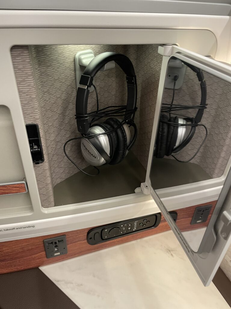 A Sneak Peek Of Hawaiian Airlines Boeing 787 Dreamliner Business Class Seats Hawaii Calling a pair of headphones inside a small cabinet
