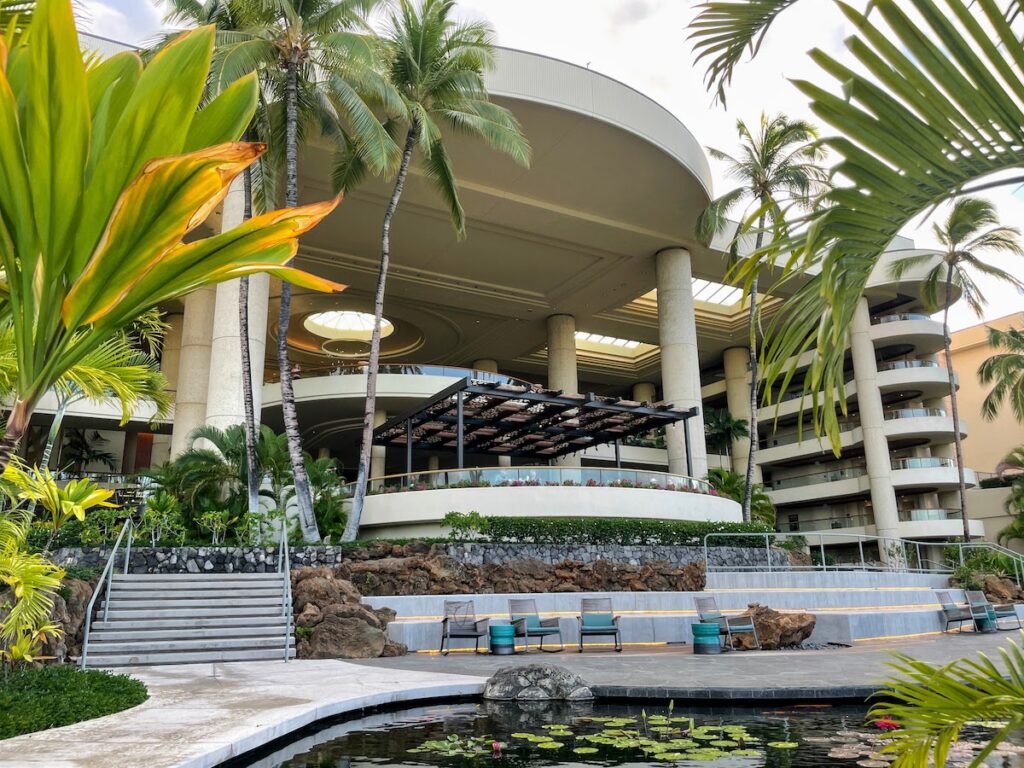 7 Best Family Hotels On The Big Island Hawaii Calling a building with a pool and palm trees