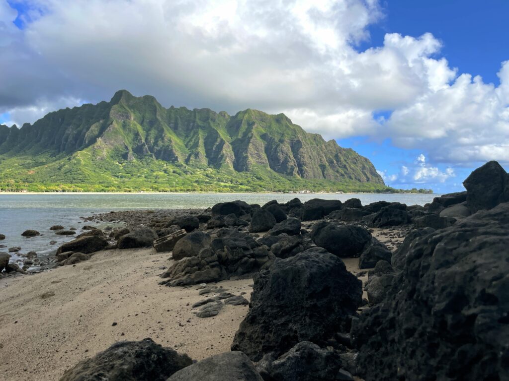 Journey to Chinamans Hat: The Fascinating Beauty of Mokoli'i Explored Hawaii Calling a rocky beach with a mountain in the background