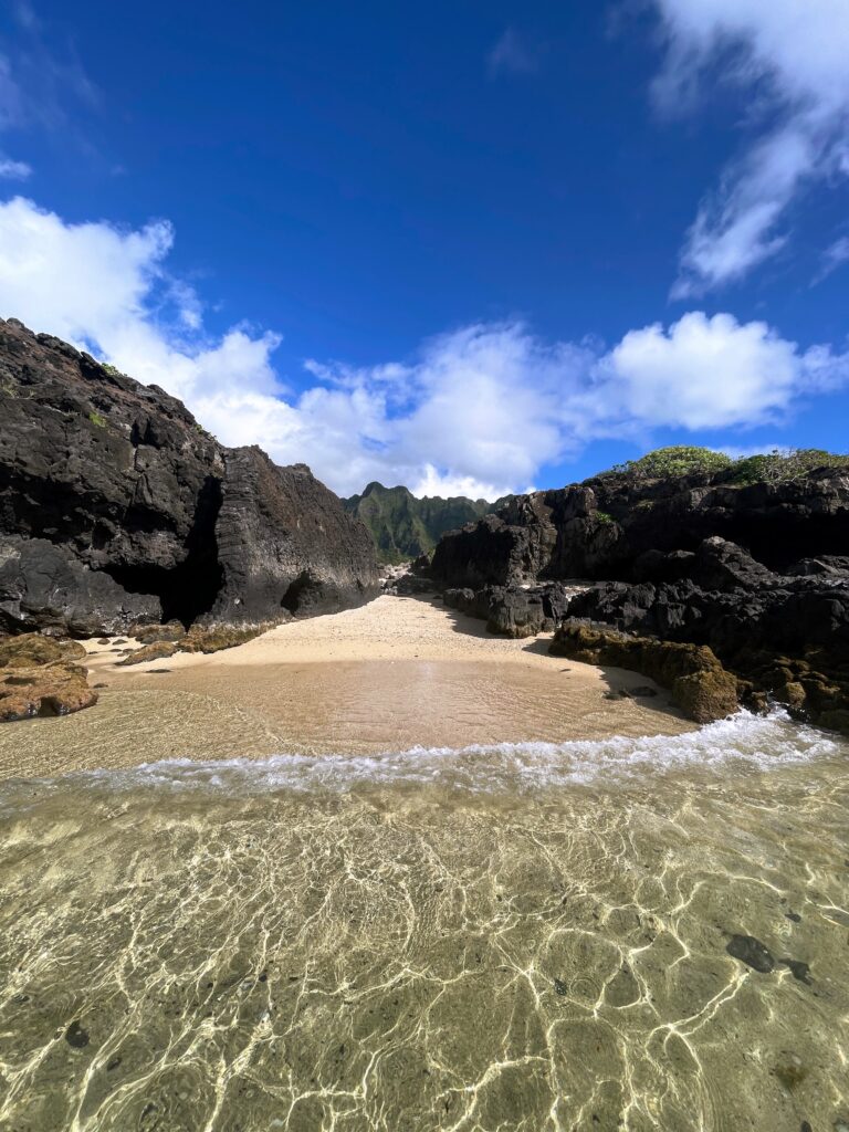 Journey to Chinamans Hat: The Fascinating Beauty of Mokoli'i Explored Hawaii Calling a sandy beach with rocks and blue sky