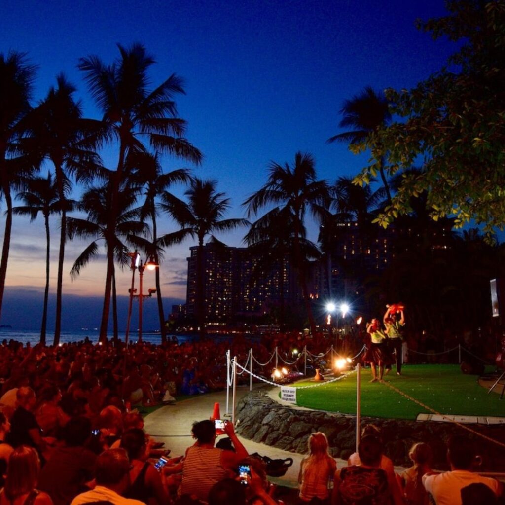 The 23 Best Things To Do In Waikiki |A Local Guide (2025) Hawaii Calling a man performing on a grass field with a crowd of people watching